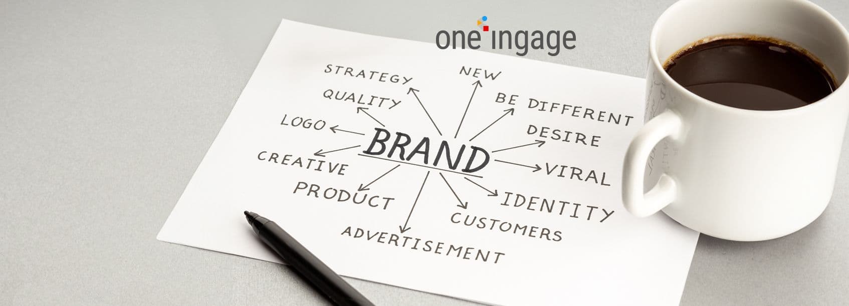 This image represents a brand manager reviewing digital brand guidelines on a laptop with various design elements.